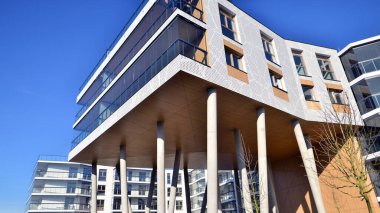 Eşsiz bir mimari çözümü olan bir apartman. Beyaz cepheli ve yüksek beton sütunların üzerinde duran modern bir yerleşim yeri..