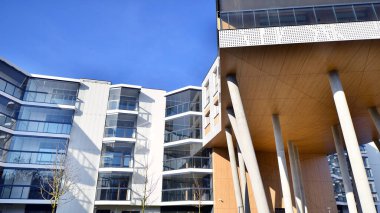 Eşsiz bir mimari çözümü olan bir apartman. Beyaz cepheli ve yüksek beton sütunların üzerinde duran modern bir yerleşim yeri..