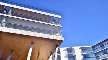 Eşsiz bir mimari çözümü olan bir apartman. Beyaz cepheli ve yüksek beton sütunların üzerinde duran modern bir yerleşim yeri..