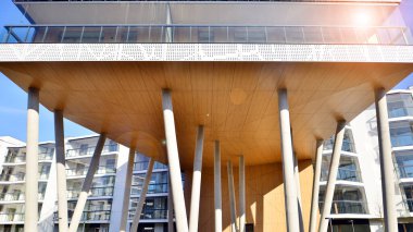 Eşsiz bir mimari çözümü olan bir apartman. Beyaz cepheli ve yüksek beton sütunların üzerinde duran modern bir yerleşim yeri..