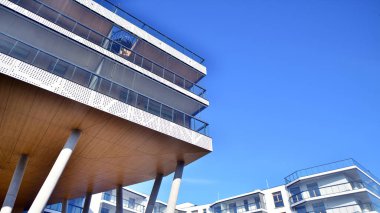 Eşsiz bir mimari çözümü olan bir apartman. Beyaz cepheli ve yüksek beton sütunların üzerinde duran modern bir yerleşim yeri..