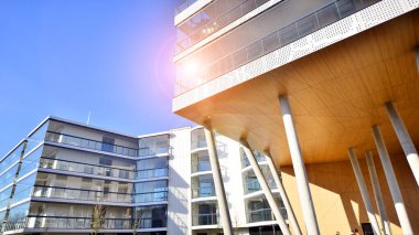 Eşsiz bir mimari çözümü olan bir apartman. Beyaz cepheli ve yüksek beton sütunların üzerinde duran modern bir yerleşim yeri..