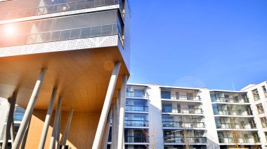 Eşsiz bir mimari çözümü olan bir apartman. Beyaz cepheli ve yüksek beton sütunların üzerinde duran modern bir yerleşim yeri..