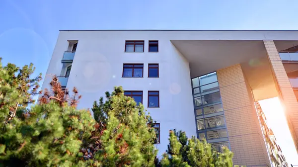 Eco city with modern exterior design of apartment building and landscaping. Garden yard by residential buildings.. Contemporary eco friendly residential architecture. Eco-friendly living in a city.