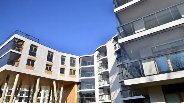 Eşsiz bir mimari çözümü olan bir apartman. Beyaz cepheli ve yüksek beton sütunların üzerinde duran modern bir yerleşim yeri..