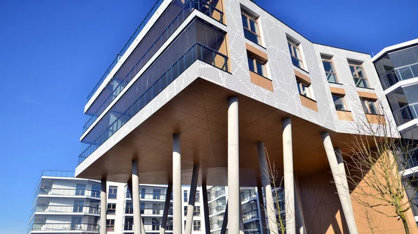 Eşsiz bir mimari çözümü olan bir apartman. Beyaz cepheli ve yüksek beton sütunların üzerinde duran modern bir yerleşim yeri..