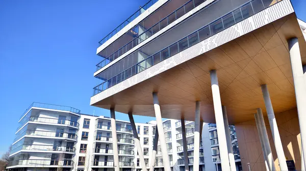 Eşsiz bir mimari çözümü olan bir apartman. Beyaz cepheli ve yüksek beton sütunların üzerinde duran modern bir yerleşim yeri..