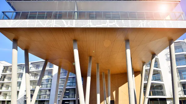 Eşsiz bir mimari çözümü olan bir apartman. Beyaz cepheli ve yüksek beton sütunların üzerinde duran modern bir yerleşim yeri..