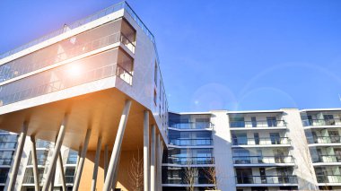 Eşsiz bir mimari çözümü olan bir apartman. Beyaz cepheli ve yüksek beton sütunların üzerinde duran modern bir yerleşim yeri..