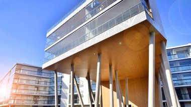 Eşsiz bir mimari çözümü olan bir apartman. Beyaz cepheli ve yüksek beton sütunların üzerinde duran modern bir yerleşim yeri..