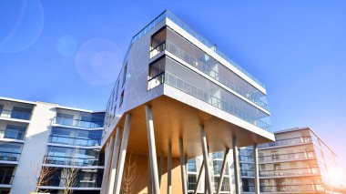 Eşsiz bir mimari çözümü olan bir apartman. Beyaz cepheli ve yüksek beton sütunların üzerinde duran modern bir yerleşim yeri..