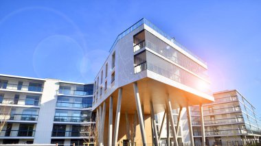 Eşsiz bir mimari çözümü olan bir apartman. Beyaz cepheli ve yüksek beton sütunların üzerinde duran modern bir yerleşim yeri..