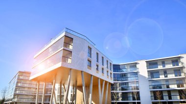 Eşsiz bir mimari çözümü olan bir apartman. Beyaz cepheli ve yüksek beton sütunların üzerinde duran modern bir yerleşim yeri..