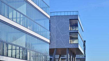 Eşsiz bir mimari çözümü olan bir apartman. Beyaz cepheli ve yüksek beton sütunların üzerinde duran modern bir yerleşim yeri..