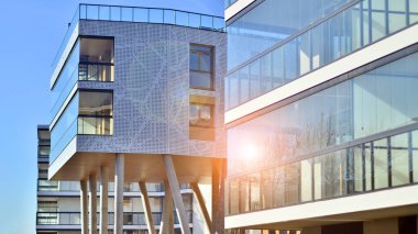 Eşsiz bir mimari çözümü olan bir apartman. Beyaz cepheli ve yüksek beton sütunların üzerinde duran modern bir yerleşim yeri..