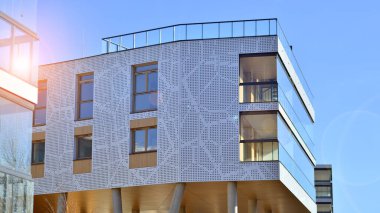 Eşsiz bir mimari çözümü olan bir apartman. Beyaz cepheli ve yüksek beton sütunların üzerinde duran modern bir yerleşim yeri..