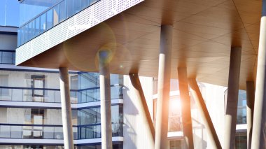 Eşsiz bir mimari çözümü olan bir apartman. Beyaz cepheli ve yüksek beton sütunların üzerinde duran modern bir yerleşim yeri..