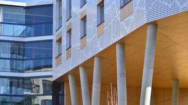 Eşsiz bir mimari çözümü olan bir apartman. Beyaz cepheli ve yüksek beton sütunların üzerinde duran modern bir yerleşim yeri..