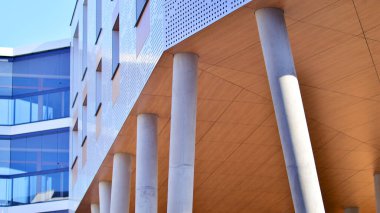 Eşsiz bir mimari çözümü olan bir apartman. Beyaz cepheli ve yüksek beton sütunların üzerinde duran modern bir yerleşim yeri..