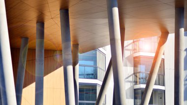 Eşsiz bir mimari çözümü olan bir apartman. Beyaz cepheli ve yüksek beton sütunların üzerinde duran modern bir yerleşim yeri..