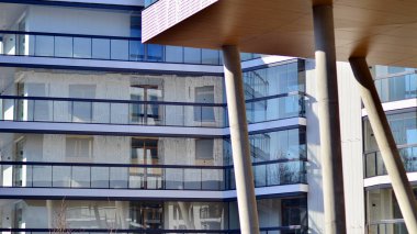 Eşsiz bir mimari çözümü olan bir apartman. Beyaz cepheli ve yüksek beton sütunların üzerinde duran modern bir yerleşim yeri..