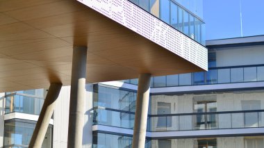 Eşsiz bir mimari çözümü olan bir apartman. Beyaz cepheli ve yüksek beton sütunların üzerinde duran modern bir yerleşim yeri..