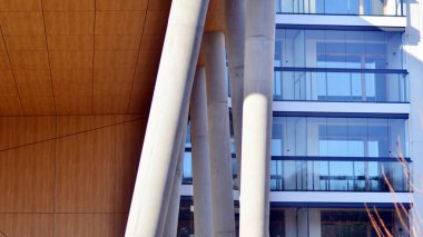 Eşsiz bir mimari çözümü olan bir apartman. Beyaz cepheli ve yüksek beton sütunların üzerinde duran modern bir yerleşim yeri..