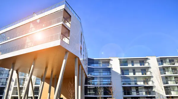 Eşsiz bir mimari çözümü olan bir apartman. Beyaz cepheli ve yüksek beton sütunların üzerinde duran modern bir yerleşim yeri..