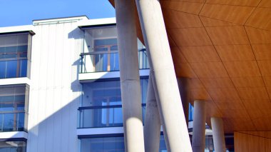 Eşsiz bir mimari çözümü olan bir apartman. Beyaz cepheli ve yüksek beton sütunların üzerinde duran modern bir yerleşim yeri..