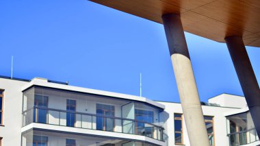 Eşsiz bir mimari çözümü olan bir apartman. Beyaz cepheli ve yüksek beton sütunların üzerinde duran modern bir yerleşim yeri..