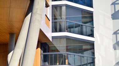 Eşsiz bir mimari çözümü olan bir apartman. Beyaz cepheli ve yüksek beton sütunların üzerinde duran modern bir yerleşim yeri..