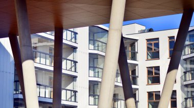 Eşsiz bir mimari çözümü olan bir apartman. Beyaz cepheli ve yüksek beton sütunların üzerinde duran modern bir yerleşim yeri..