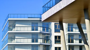 Eşsiz bir mimari çözümü olan bir apartman. Beyaz cepheli ve yüksek beton sütunların üzerinde duran modern bir yerleşim yeri..