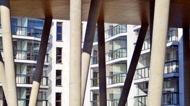 Eşsiz bir mimari çözümü olan bir apartman. Beyaz cepheli ve yüksek beton sütunların üzerinde duran modern bir yerleşim yeri..