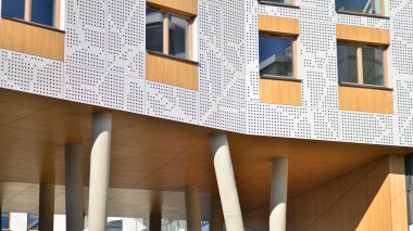 Eşsiz bir mimari çözümü olan bir apartman. Beyaz cepheli ve yüksek beton sütunların üzerinde duran modern bir yerleşim yeri..