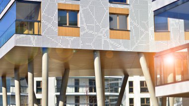 Eşsiz bir mimari çözümü olan bir apartman. Beyaz cepheli ve yüksek beton sütunların üzerinde duran modern bir yerleşim yeri..