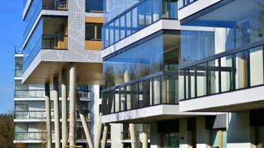 Eşsiz bir mimari çözümü olan bir apartman. Beyaz cepheli ve yüksek beton sütunların üzerinde duran modern bir yerleşim yeri..