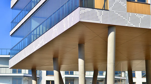 Eşsiz bir mimari çözümü olan bir apartman. Beyaz cepheli ve yüksek beton sütunların üzerinde duran modern bir yerleşim yeri..