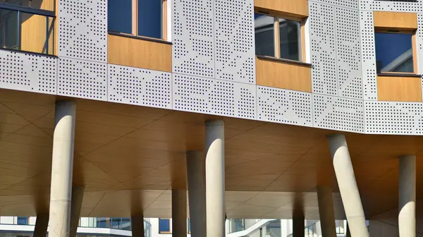 Eşsiz bir mimari çözümü olan bir apartman. Beyaz cepheli ve yüksek beton sütunların üzerinde duran modern bir yerleşim yeri..