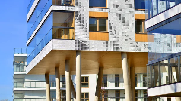 Eşsiz bir mimari çözümü olan bir apartman. Beyaz cepheli ve yüksek beton sütunların üzerinde duran modern bir yerleşim yeri..