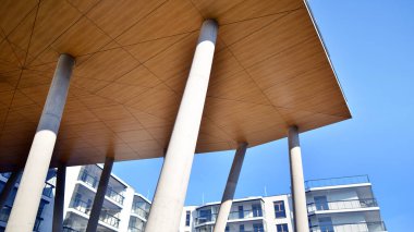 Eşsiz bir mimari çözümü olan bir apartman. Beyaz cepheli ve yüksek beton sütunların üzerinde duran modern bir yerleşim yeri..