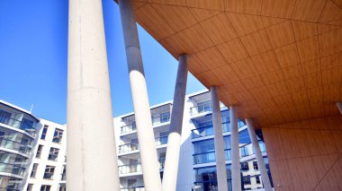 Eşsiz bir mimari çözümü olan bir apartman. Beyaz cepheli ve yüksek beton sütunların üzerinde duran modern bir yerleşim yeri..