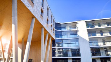 Eşsiz bir mimari çözümü olan bir apartman. Beyaz cepheli ve yüksek beton sütunların üzerinde duran modern bir yerleşim yeri..