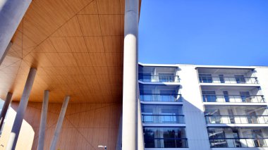 Eşsiz bir mimari çözümü olan bir apartman. Beyaz cepheli ve yüksek beton sütunların üzerinde duran modern bir yerleşim yeri..