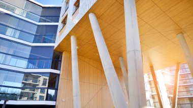 Eşsiz bir mimari çözümü olan bir apartman. Beyaz cepheli ve yüksek beton sütunların üzerinde duran modern bir yerleşim yeri..