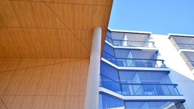 Eşsiz bir mimari çözümü olan bir apartman. Beyaz cepheli ve yüksek beton sütunların üzerinde duran modern bir yerleşim yeri..