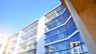 Eşsiz bir mimari çözümü olan bir apartman. Beyaz cepheli ve yüksek beton sütunların üzerinde duran modern bir yerleşim yeri..