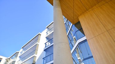 Eşsiz bir mimari çözümü olan bir apartman. Beyaz cepheli ve yüksek beton sütunların üzerinde duran modern bir yerleşim yeri..