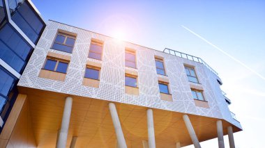 Eşsiz bir mimari çözümü olan bir apartman. Beyaz cepheli ve yüksek beton sütunların üzerinde duran modern bir yerleşim yeri..