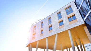 Eşsiz bir mimari çözümü olan bir apartman. Beyaz cepheli ve yüksek beton sütunların üzerinde duran modern bir yerleşim yeri..